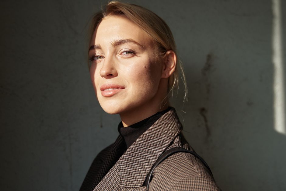 Striking headshot of a confident woman with soft light and shadows.