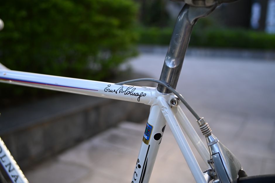 Detailed view of a vintage Colnago bicycle frame with signature, captured outdoors.