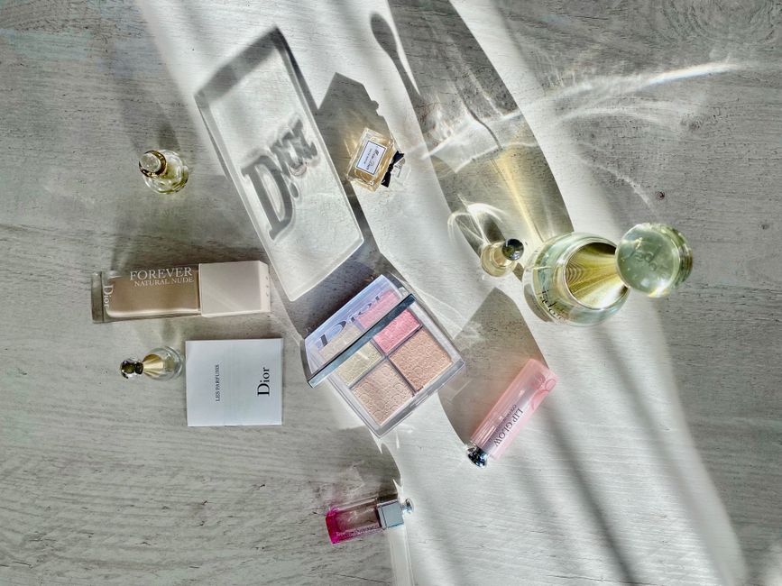 High-angle shot of Dior cosmetics and perfumes casting artistic shadows.