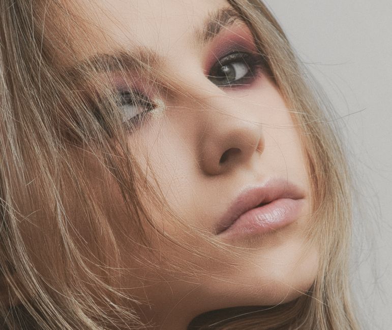 Close-up portrait of a woman with artistic makeup, enhancing natural beauty and elegance.