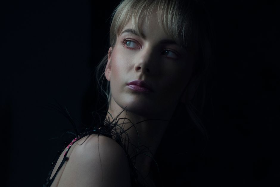 A captivating portrait of a woman with dramatic lighting and dark background.