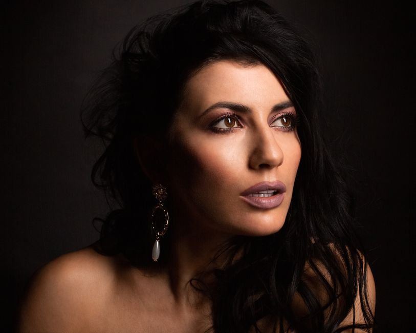 Artistic portrait of a woman with striking makeup and jewelry. Captivating elegance.