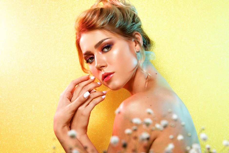 Captivating studio portrait of a woman posing against a vibrant yellow background.